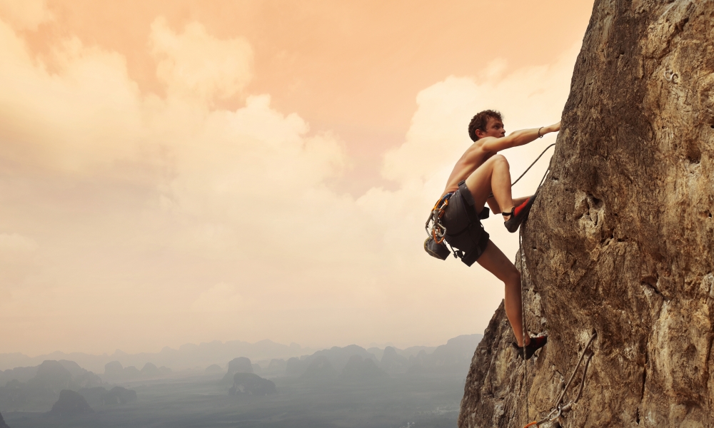 athletic man climbing a mountain