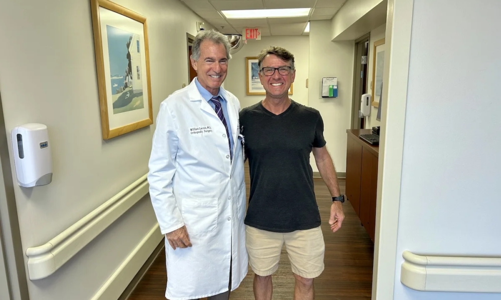Larry Heath stands with Dr. Leone. Happy about his SPAIRE total hip.