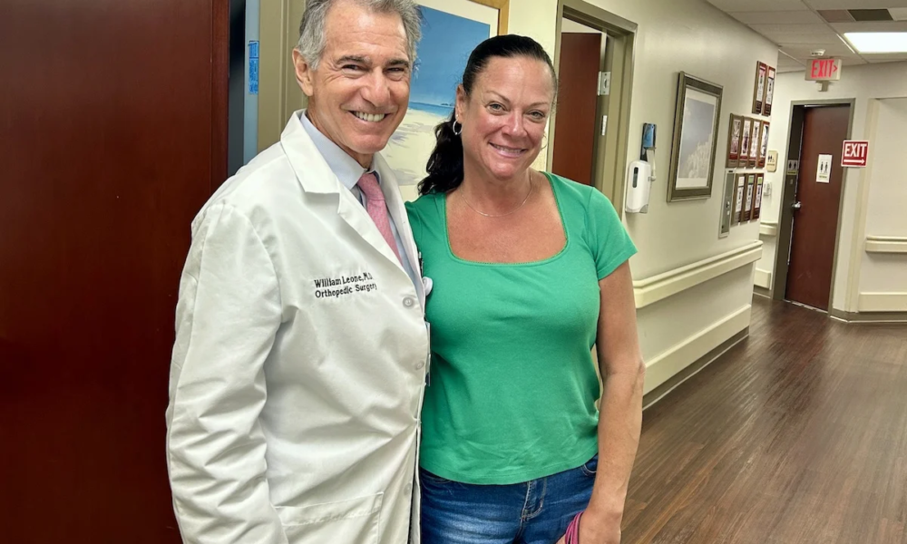 A female patient is standing next to Dr. Leone in his office. She had her 6 week check up.