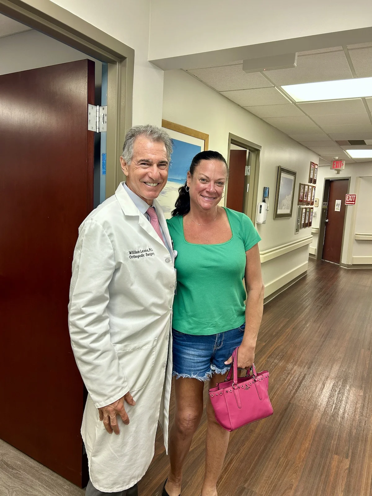 A female patient is standing next to Dr. Leone in his office. She had her 6 week check up.